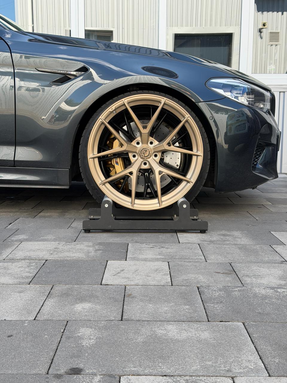 Кованый диск WS FORGED WS-088C R20 на стенде у передней части BMW M5 F90